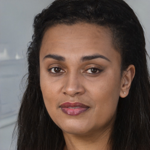 Joyful black young-adult female with long  brown hair and brown eyes