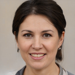 Joyful white adult female with medium  brown hair and brown eyes