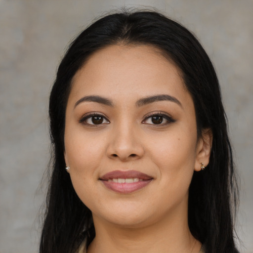 Joyful latino young-adult female with long  brown hair and brown eyes