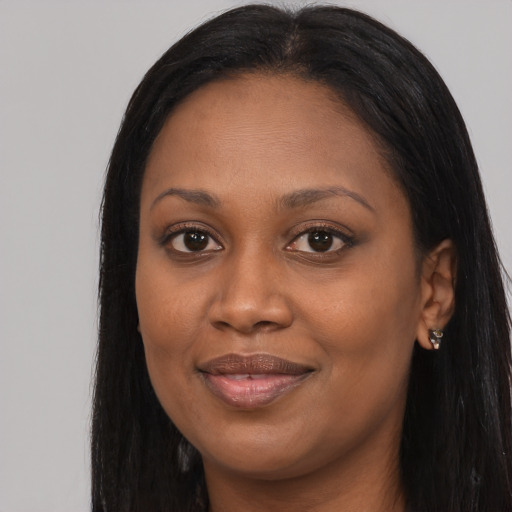 Joyful black young-adult female with long  black hair and brown eyes
