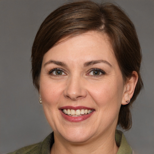 Joyful white adult female with medium  brown hair and grey eyes