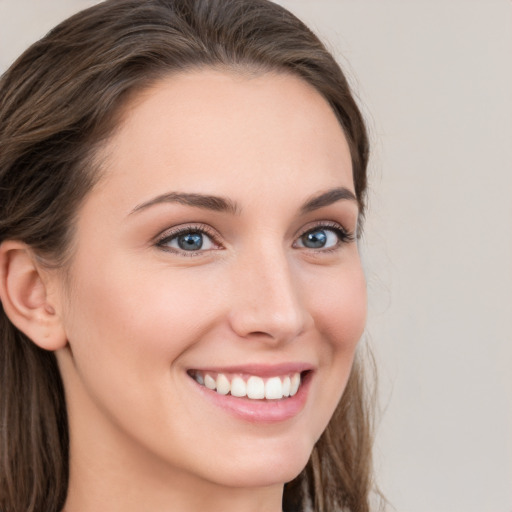 Joyful white young-adult female with long  brown hair and grey eyes