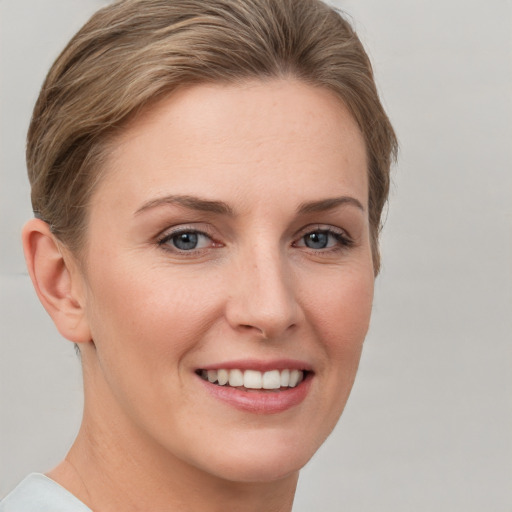 Joyful white young-adult female with short  brown hair and grey eyes