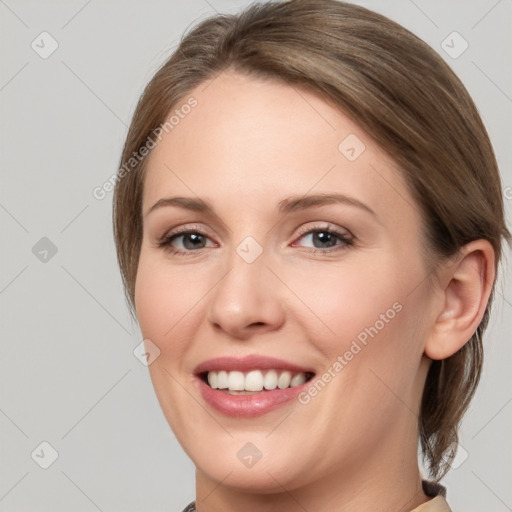 Joyful white young-adult female with medium  brown hair and grey eyes