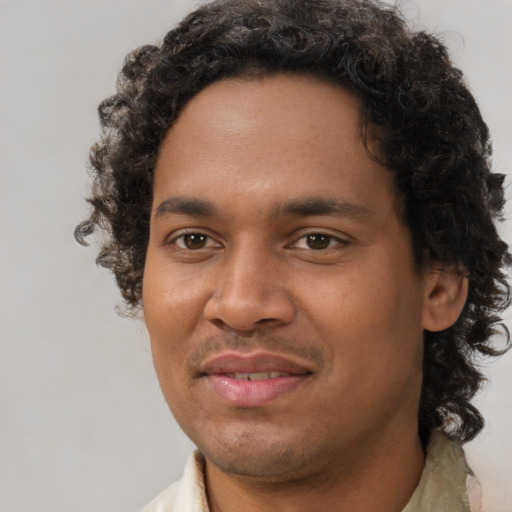 Joyful black young-adult male with short  brown hair and brown eyes