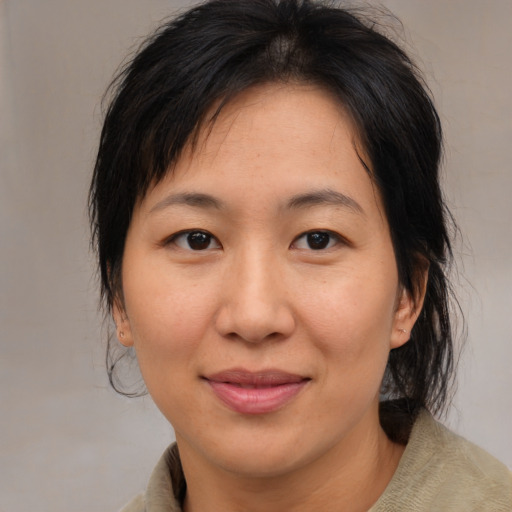 Joyful asian adult female with medium  brown hair and brown eyes