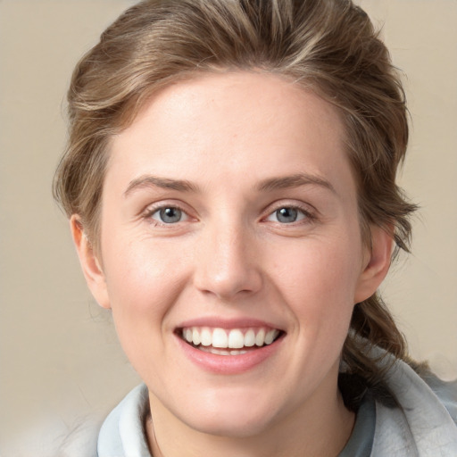 Joyful white young-adult female with medium  brown hair and blue eyes