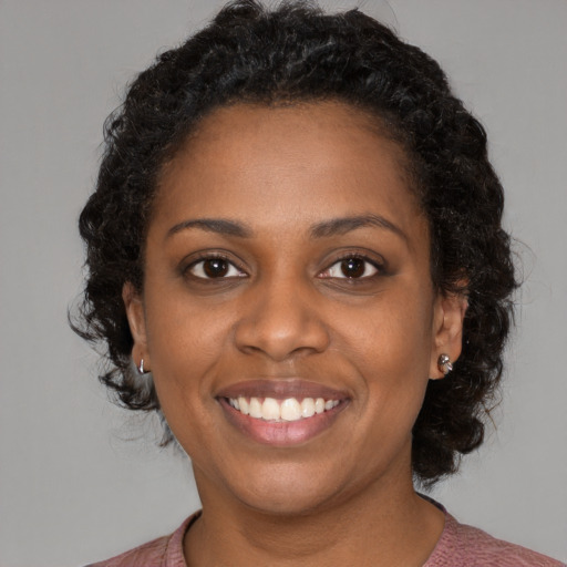 Joyful black young-adult female with medium  black hair and brown eyes
