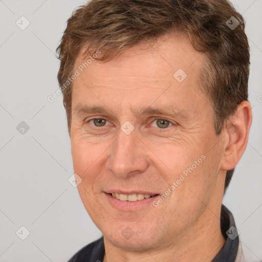 Joyful white adult male with short  brown hair and brown eyes