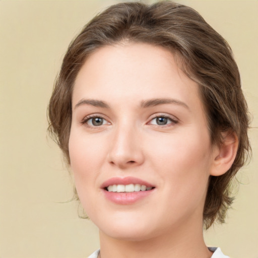 Joyful white young-adult female with medium  brown hair and green eyes