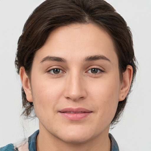 Joyful white young-adult female with medium  brown hair and grey eyes