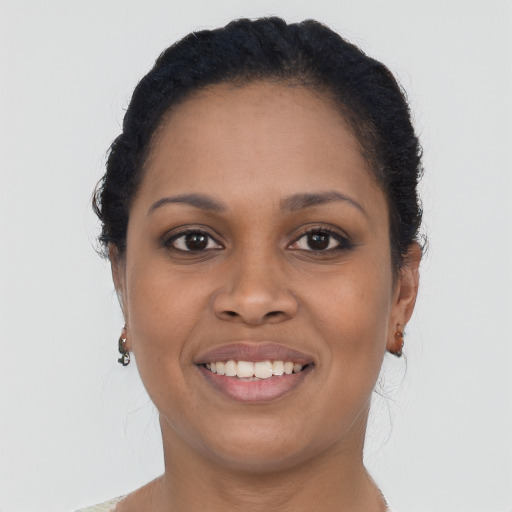 Joyful black young-adult female with long  brown hair and brown eyes