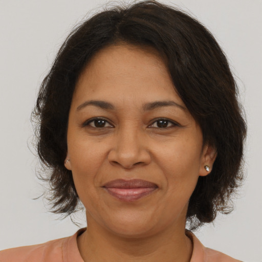 Joyful latino adult female with medium  brown hair and brown eyes