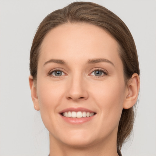 Joyful white young-adult female with medium  brown hair and grey eyes