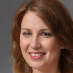 Joyful white adult female with long  brown hair and brown eyes