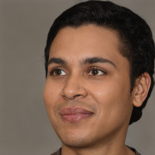 Joyful latino young-adult male with short  black hair and brown eyes