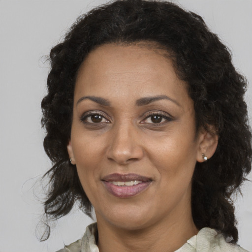 Joyful black adult female with medium  brown hair and brown eyes