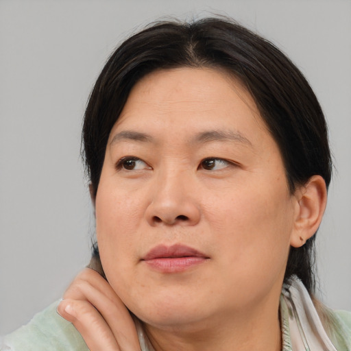 Joyful asian adult female with medium  brown hair and brown eyes
