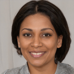 Joyful black young-adult female with medium  brown hair and brown eyes