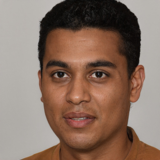 Joyful black young-adult male with short  black hair and brown eyes