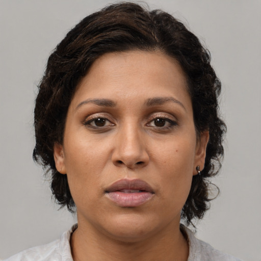 Joyful latino adult female with medium  brown hair and brown eyes