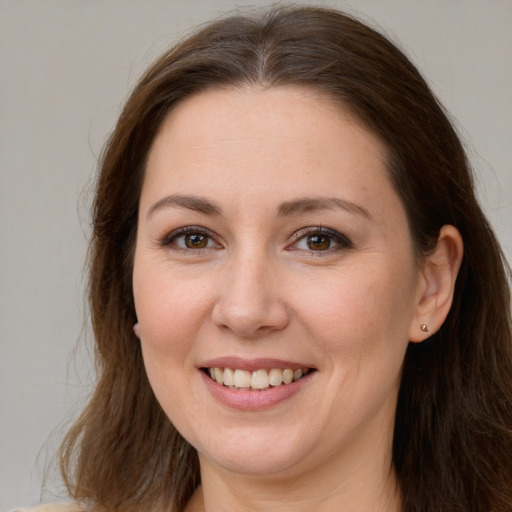 Joyful white young-adult female with long  brown hair and brown eyes