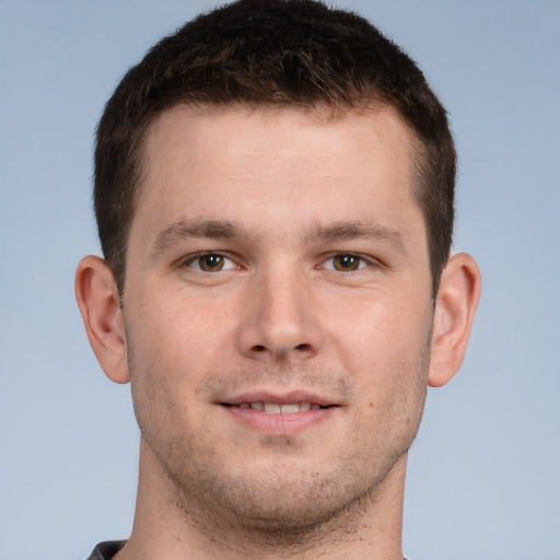 Joyful white young-adult male with short  brown hair and grey eyes