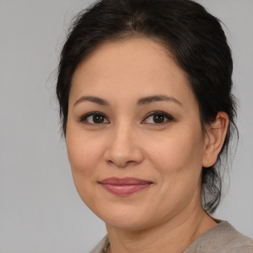 Joyful latino young-adult female with medium  brown hair and brown eyes