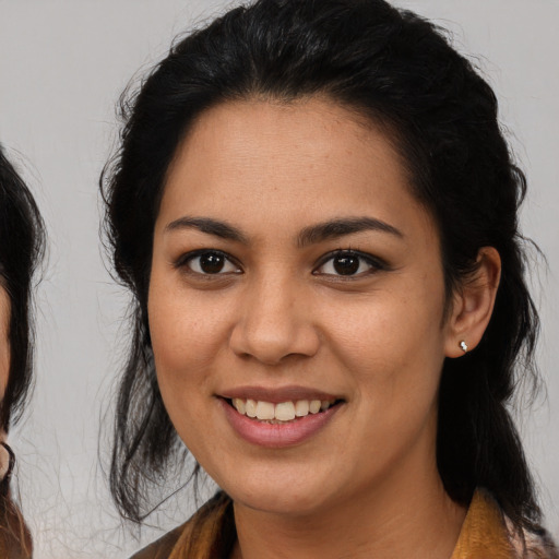 Joyful latino young-adult female with medium  brown hair and brown eyes