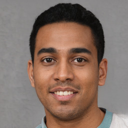 Joyful latino young-adult male with short  black hair and brown eyes