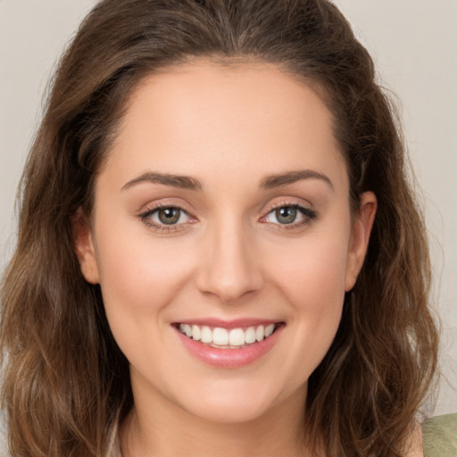 Joyful white young-adult female with long  brown hair and green eyes