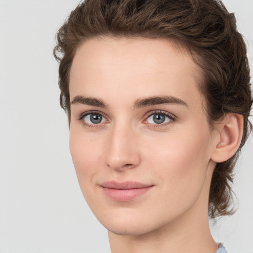 Joyful white young-adult female with medium  brown hair and green eyes