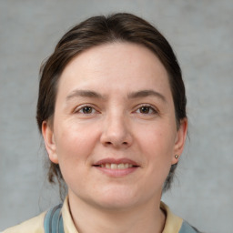 Joyful white young-adult female with medium  brown hair and grey eyes