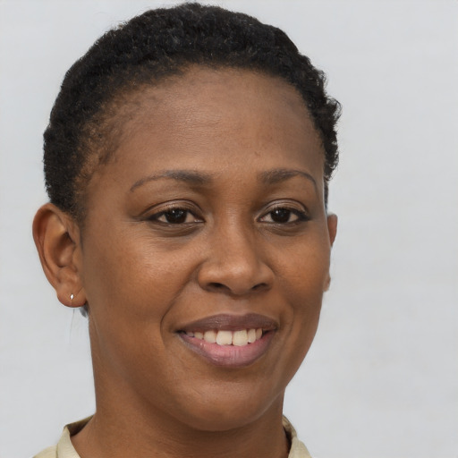 Joyful black young-adult female with short  brown hair and brown eyes