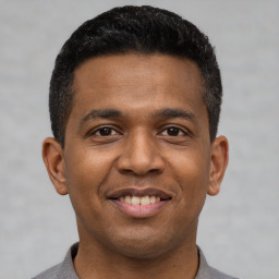 Joyful latino young-adult male with short  black hair and brown eyes