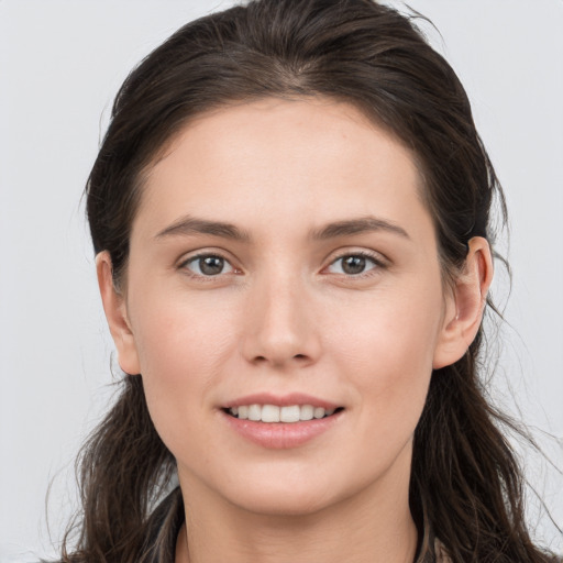 Joyful white young-adult female with long  brown hair and brown eyes