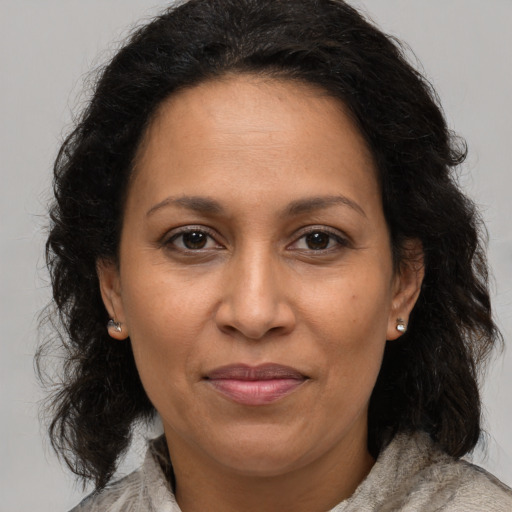 Joyful latino adult female with long  brown hair and brown eyes