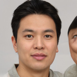 Joyful asian young-adult male with short  brown hair and brown eyes