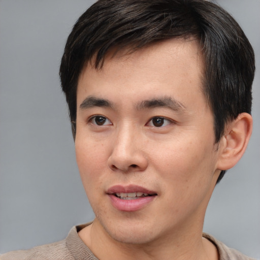 Joyful asian young-adult male with short  brown hair and brown eyes