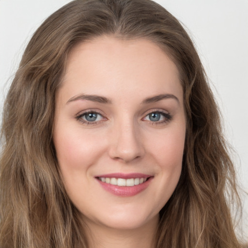 Joyful white young-adult female with long  brown hair and green eyes