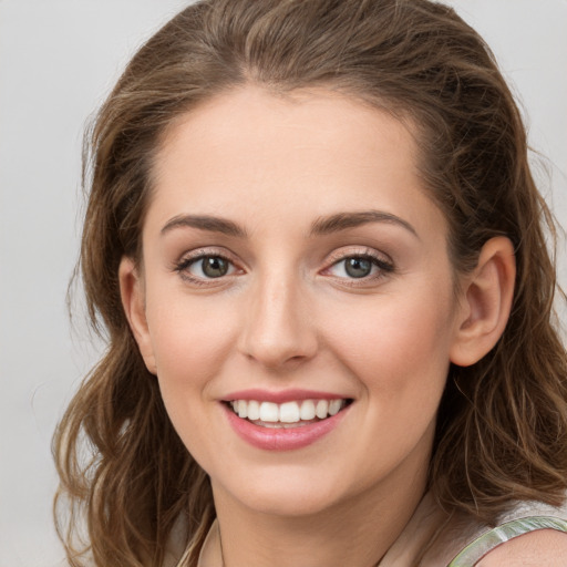 Joyful white young-adult female with long  brown hair and green eyes