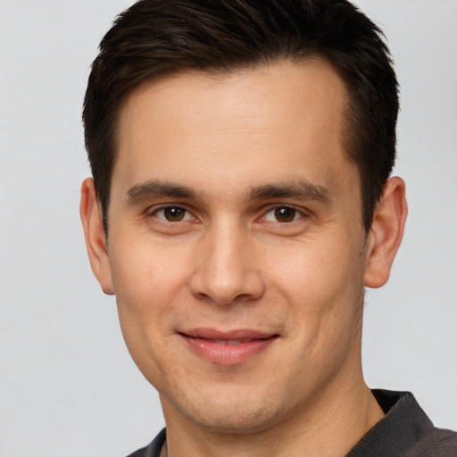 Joyful white young-adult male with short  brown hair and brown eyes