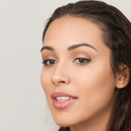 Joyful latino young-adult female with long  brown hair and brown eyes