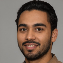 Joyful latino young-adult male with short  black hair and brown eyes