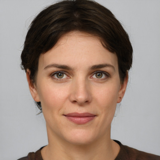 Joyful white young-adult female with short  brown hair and green eyes