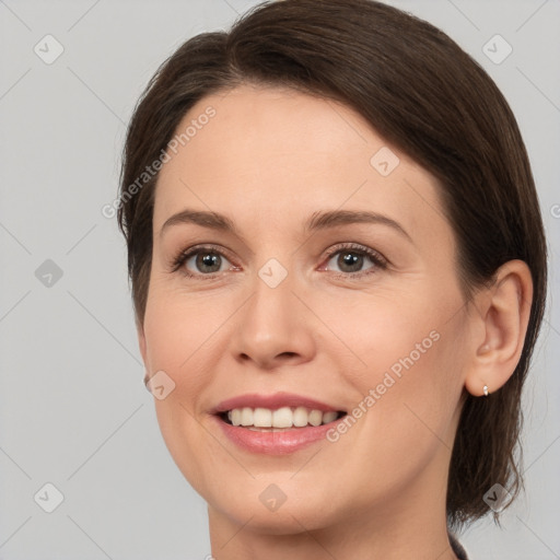 Joyful white young-adult female with medium  brown hair and grey eyes