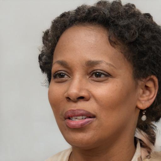 Joyful black adult female with short  brown hair and brown eyes
