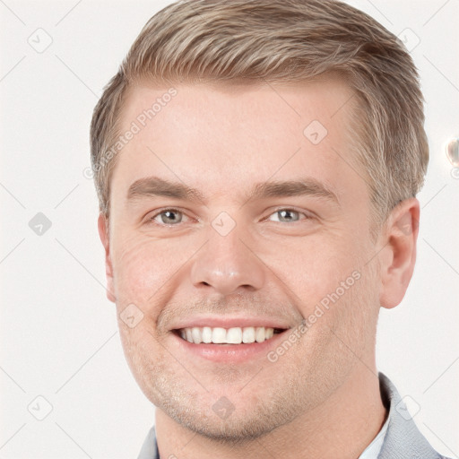 Joyful white young-adult male with short  brown hair and grey eyes