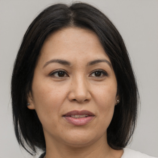 Joyful asian adult female with medium  brown hair and brown eyes