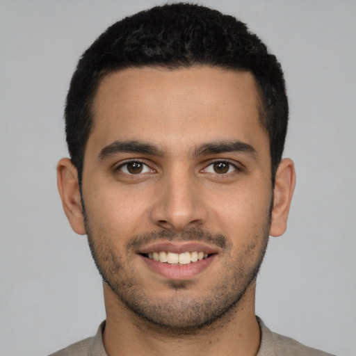 Joyful latino young-adult male with short  brown hair and brown eyes